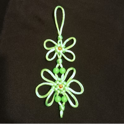 Плетеное украшение  с цветками и бусинами. Подвеска сплетена из зеленого шнура.